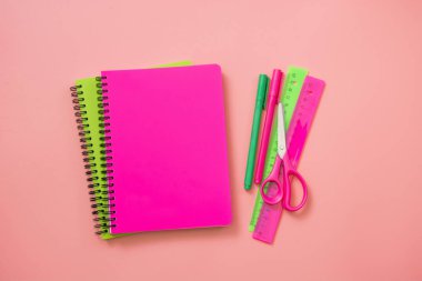 Üzerine pastel pembe renkli okul malzemeleri. Üstten görünüm, düz yatıyordu. Metin için yer.