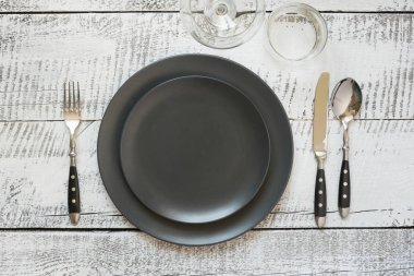 Beyaz ahşap masa üzerinde siyah plaka ile masa yeri ayarı. Üstte görüntü.