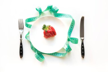 Şerit mezuralı beyaz masa ve çirkin organik çilek. Detox için kavram kilo kaybı.