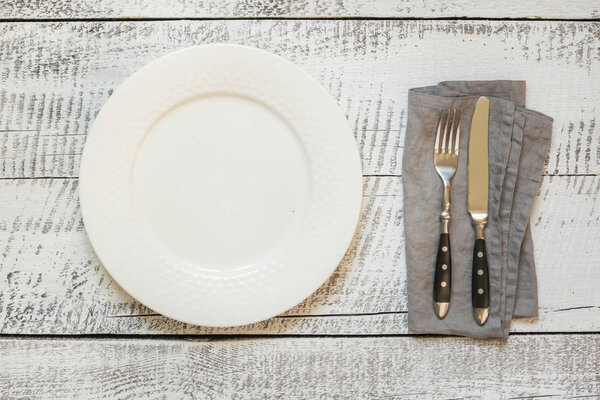 Elegant table place setting on white wooden table. Top view.