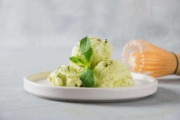 Grön matcha-glass och mynta på grått bord. — Stockfoto
