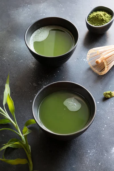 有机两个绿色火柴茶在碗黑表. — 图库照片