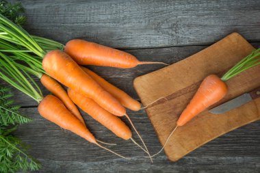 Taze organik havuç ile ahşap masa, closeup yeşil başında. Üstten Görünüm. Pişirme