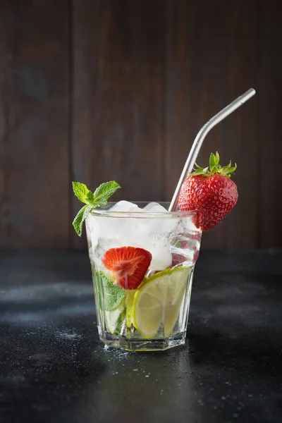 排毒柠檬水或莫吉托与石灰，柠檬，草莓在岩石玻璃。夏季健康饮料. — 图库照片
