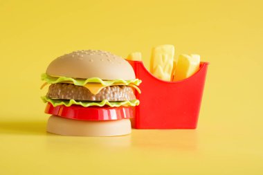 Plastik burger, salata, domates, sarı ile patates kızartma.