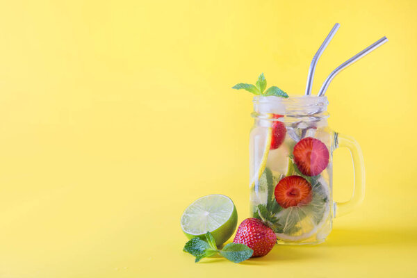 Detox water or mojito with lime, strawberry in glass. Summer healthy freshness drink. Close up.