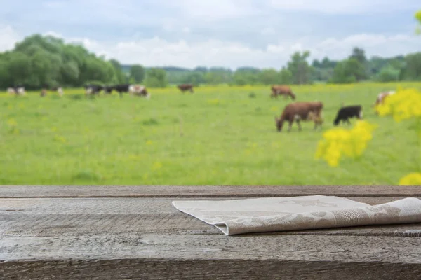 Пустой деревянный стол и размытый сельский фон коров на зеленом поле. Мбаппе для вашего продукта . — стоковое фото