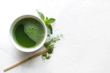 Tören yeşil matcha çay ve bambu çırpıcı beyaz beton masada. Üstte görüntü.