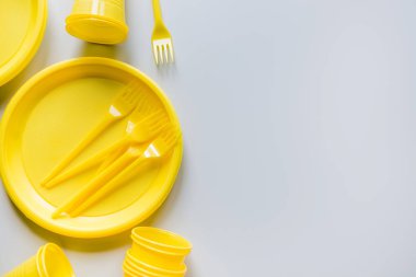 gri geri dönüşüm için tek kullanımlık piknik sarı gereçleri. Çevre, çevre dostu, geri dönüşüm konsepti için plastik çöp. Üst te. Metin için alan.