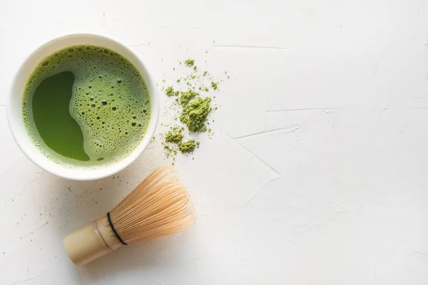 Teh matcha hijau upacara dan whisk bambu di atas meja beton putih. Pemandangan bagus. Ruang untuk teks . — Stok Foto