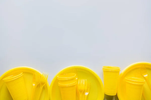 単一の使用ピクニック黄色の道具、プレート、カップ、灰色のフォーク。トップビュー。テキスト用のスペース. — ストック写真