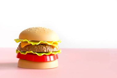 Plastik burger, salata, pembe ile domates.
