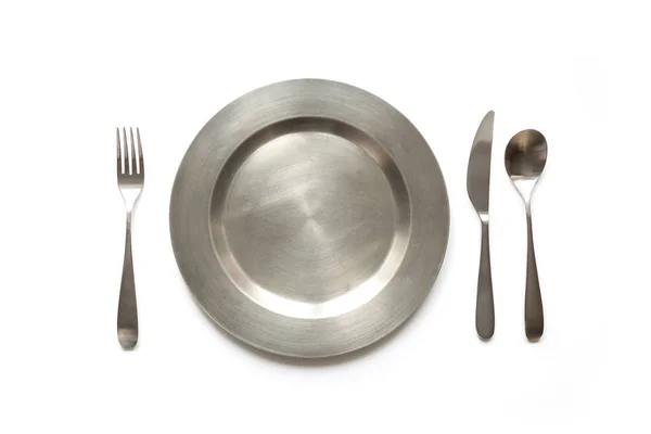Empty metal dish with knife and fork on white background, with copy space. Table setting. — Stock Photo, Image
