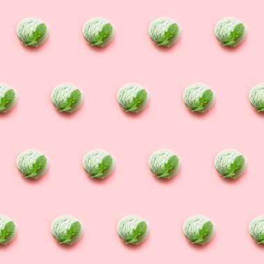 Pembe arka planda nane ile bir yeşil antep fıstığı veya matcha çay dondurma topu. Yukarıdan görüntüle.