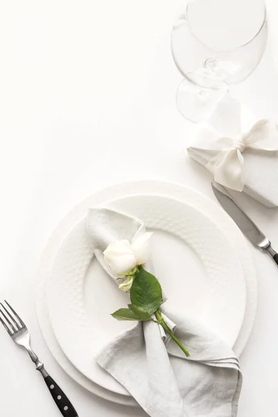 Романтична та весільна обстановка столу з білою трояндою, подарунком, посудом, посудом на білому столі. Переглянути згори . — стокове фото