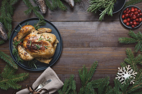 Traditional Christmas roasted turkey with spices and rosemary on wooden table. Top view.