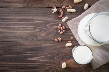 Cam ve koyu ahşap masada sürahi taze fıstık sütü. Rustik tarzı.