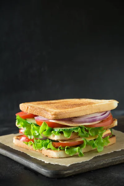 Sandwich with bacon,tomato, onion, salad on black background. Isolated. — Stock Photo, Image