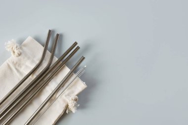 Gri pamuk torba ile eko doğal metalik pipetler. Sürdürülebilir yaşam tarzı kavramı. Sıfır atık, plastik içermez. Kirlilik ortamı.