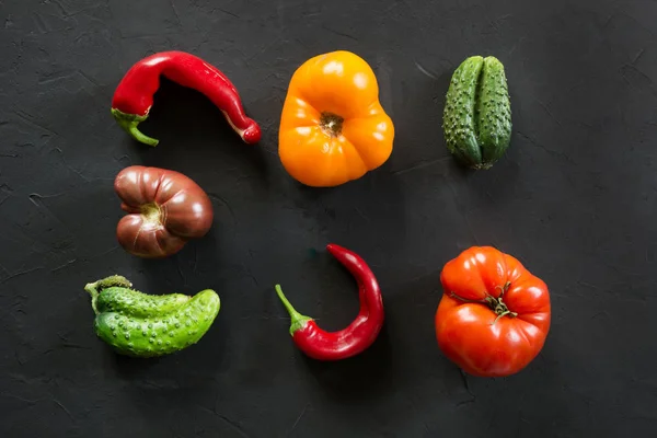 Feo tomate colorido orgánico, pimienta, pepino en negro . —  Fotos de Stock