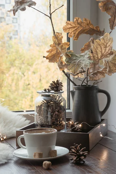 Fall cozy still life on windowsill at home interior. Cup of coffee at home warm fluffy furskin. Hygge.