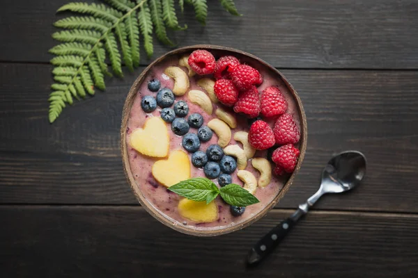 Здоровый завтрак банан и черничный смузи украшены фруктами в кокосовой миске. — стоковое фото