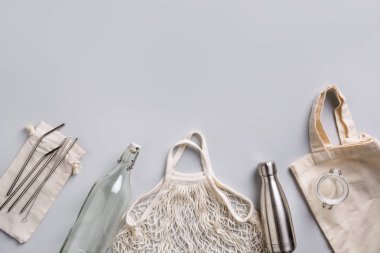 Yeniden kullanılabilir cam ve metal şişe, gri sıfır atık yaşam tarzı için örgü çanta. Ücretsiz plastik.