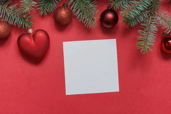 Kerst grens van rode ballen en hart, groenblijvende takken op rood. Uitzicht vanaf boven, vlakke lag. Xmas vakantie. Sjabloon, mockup, nieuwe jaar kaart groet. — Stockfoto