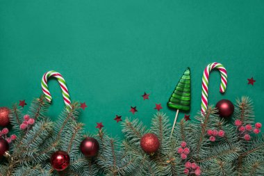 Noel ağacı dalları, kopya alanı ile yeşil kırmızı cam topları. Üst te. Tatil kartı.