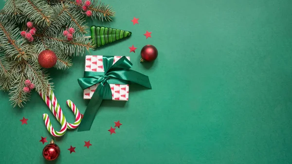 복사 공간이있는 녹색에 크리스마스 나무 가지, 빨간 유리 공과 선물 상자. 맨 위 보기. 홀리데이 카드. — 스톡 사진