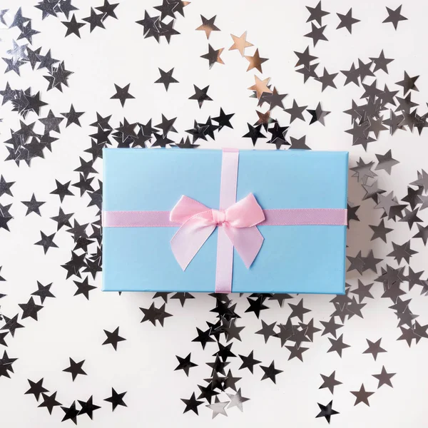 Christmas Blue Gift Box op witte tafel met zilveren sprankelende ster. Xmas. Platte lag. Bovenaanzicht. Wenskaart voor verjaardag of Kerstmis. — Stockfoto