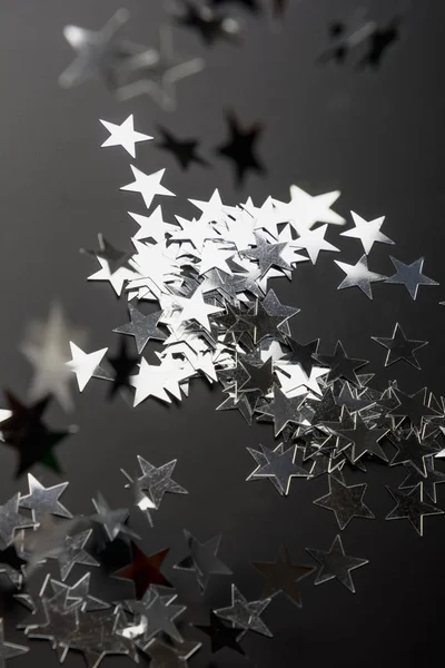 Estrellas plateadas brillan sobre fondo negro. Fondo festivo de vacaciones . — Foto de Stock