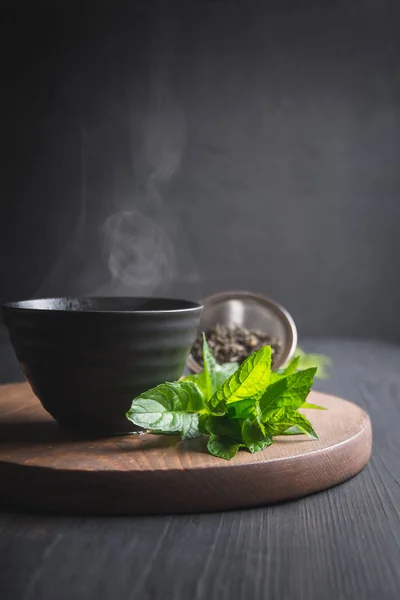 Forró tea a menta fekete csésze sötét háttér. Kínai tea. — Stock Fotó