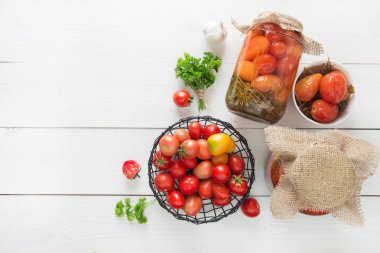 Ahşap tahta üzerinde cam kavanozlarda konserve sebze domates. Yukarıdan görüntüleyin. Metin için alan.