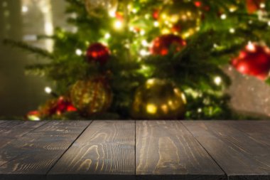 Koyu ahşap masa ve bulanık Noel ağacı bokeh. Xmas arka plan için ürün görüntüleme.