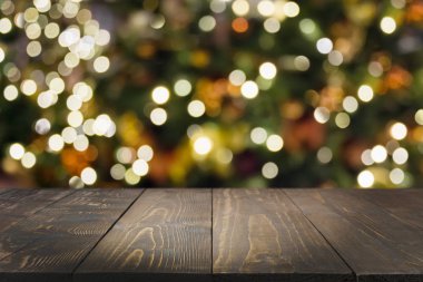 Wooden dark tabletop and blurred christmas tree bokeh. Xmas background for display your products. clipart