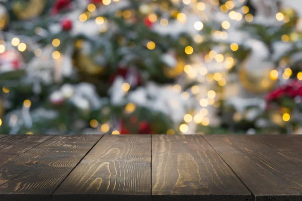 Koyu ahşap masa ve bulanık Noel ağacı bokeh. Xmas arka plan için ürün görüntüleme.