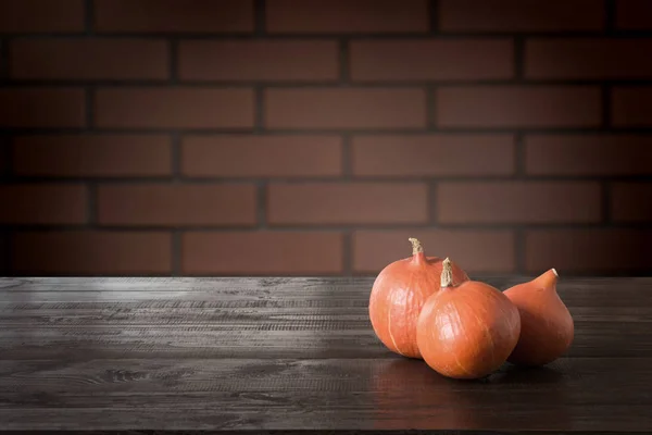 Tablero de madera con pared de calabaza y ladrillo. Fondo de Halloween. Mock up para montaje en pantalla de producto . — Foto de Stock