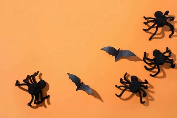 Halloween-Bordüre von Spinnen und Fledermäusen auf orangefarbenem Papier. flache Lage, Draufsicht. Kreative Zusammensetzung des Halloween-Tages. — Stockfoto