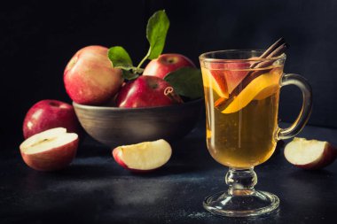 Siyah tahtaüzerinde limon ve tarçın ile sıcak elma çayı bardak. Sonbahar natürmort.