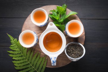 Çay seremonisi. Koyu renkte naneli ve çaydanlıklı üç fincan çay. Çin çayı konsepti. Yukarıdan görüntüle.