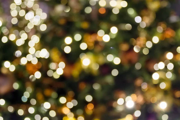 Blurred Christmas tree with golden garland and balls in night. Abstract pattern. Xmas. — Stock Photo, Image