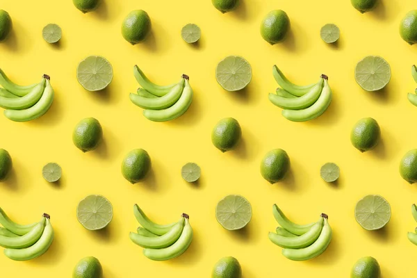 Seamless tropical pattern bananas, limes on yellow background. Creative food concept. Flat lay. Top view.