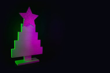 Neon pembeli Noel ağacı ve siyah üzerine yeşil ışınlar. Metin ve tatil dilekleri için alanı olan yaratıcı Xmas deseni.