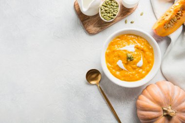 Gri taşlı arka planda kremalı balkabağı çorbası. Uzayı kopyala Üst görünüm.