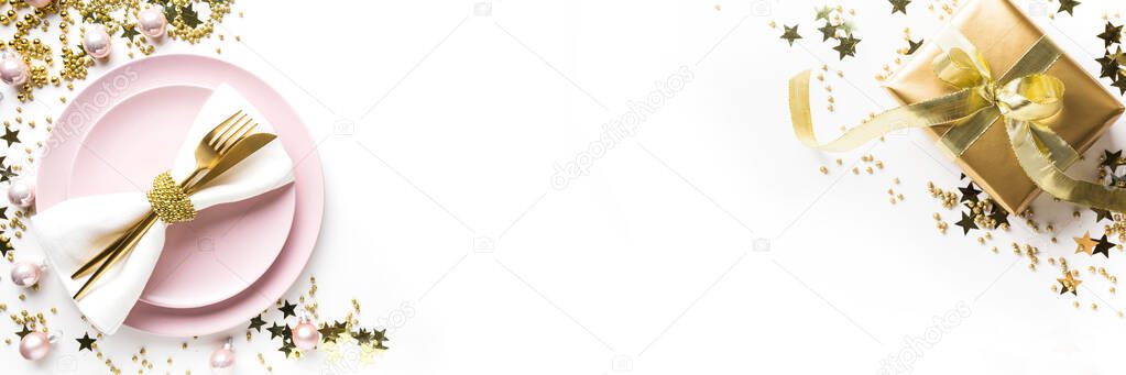 Christmas banner. Table setting with golden dishware, silverware on white. Top view.