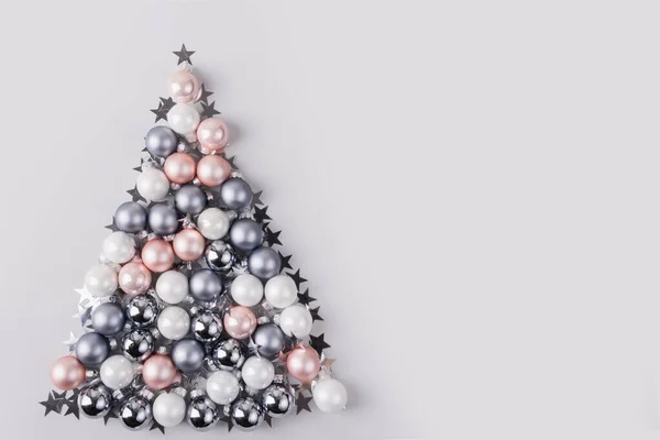 Albero di Natale fatto di stelle, coriandoli, palline color argento pastello su sfondo grigio. Composizione natalizia. Posa piatta, vista dall'alto, copiare spazio. Biglietto di auguri vacanze . — Foto Stock