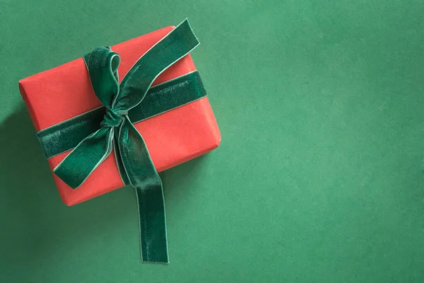 Christmas red giftwit green velvet ribbon on green — Stock fotografie