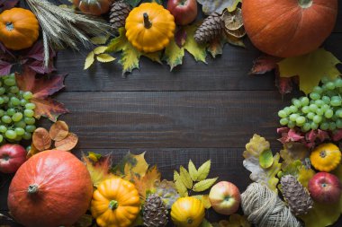 Şükran Günü. Sonbahar hasadı, balkabakları ve ahşap tahtada renkli akçaağaç yaprakları. Düşme düzeni. Üst görünüm.