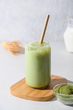 Beyaz arka planda buzlu yeşil kibrit sütlü çay. Kapatın. Dikey biçim.